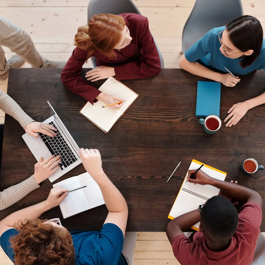 Equipo de profesionales conversando alrededor de una mesa