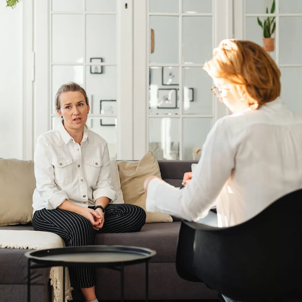 Dos personas conversando sentadas frente a frente