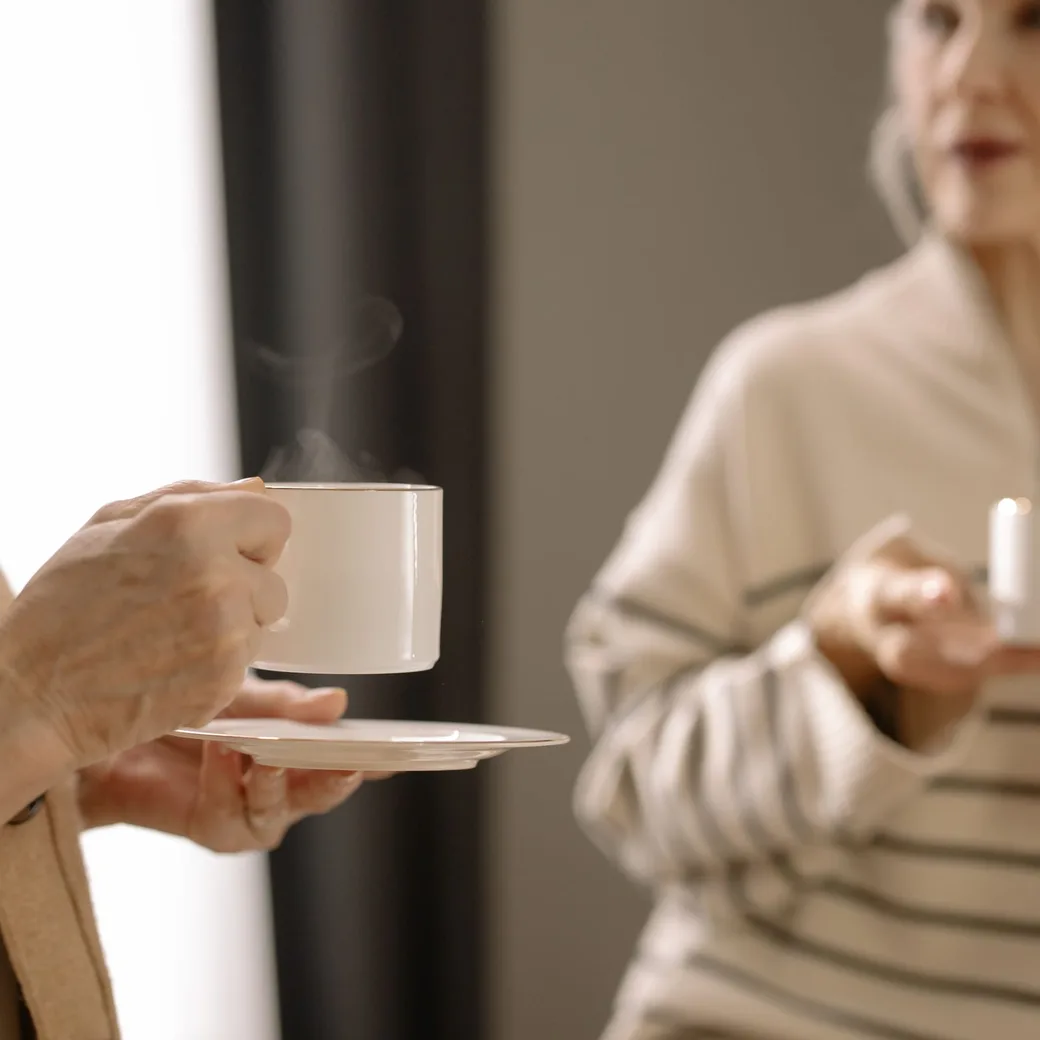Dos personas conversando con calma junto a unas tazas