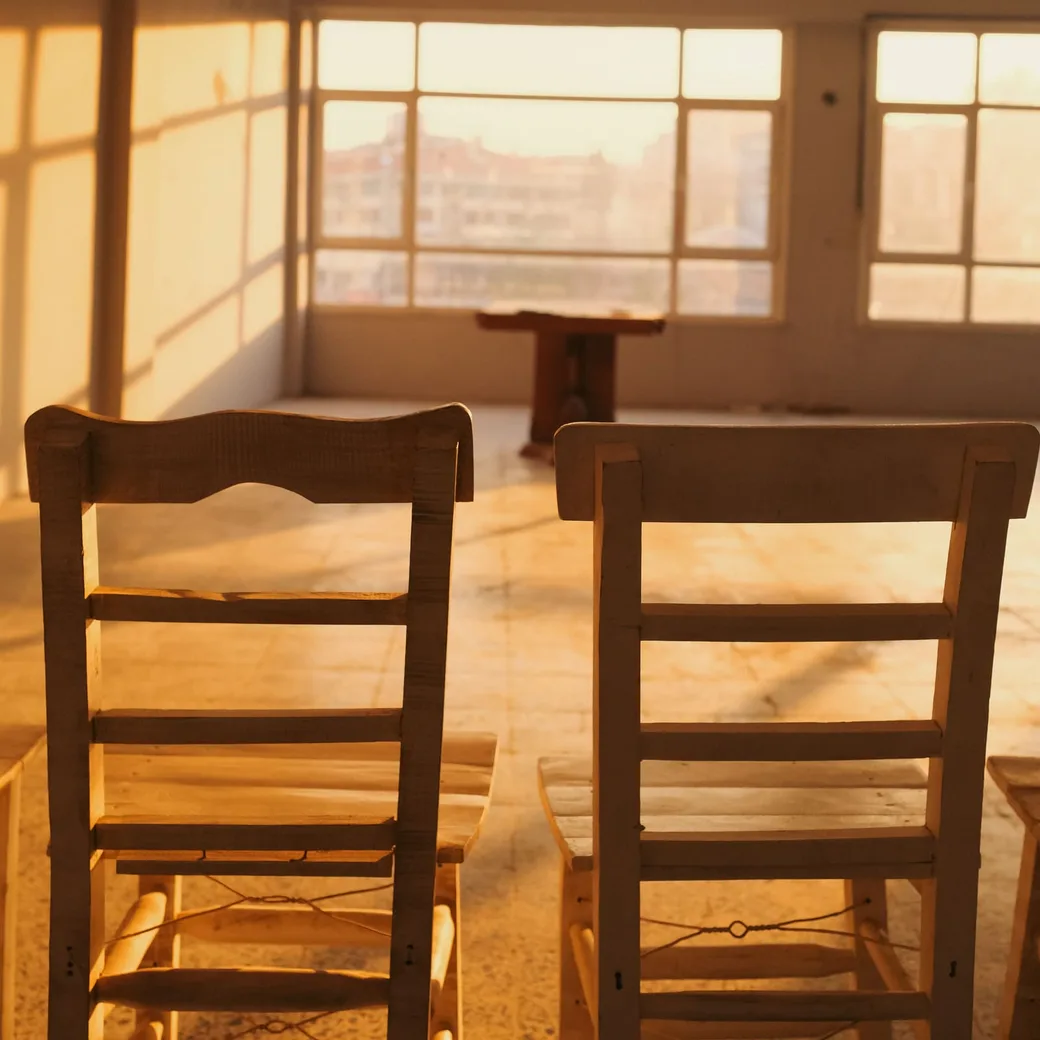 Dos sillas vacías en una sala con luz de tarde